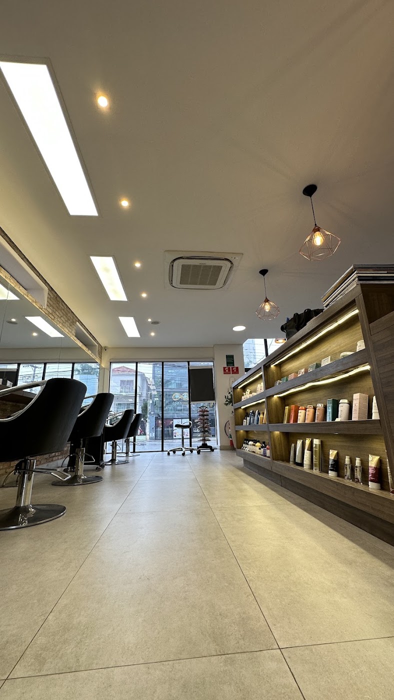 Interior do salão com espelhos e cadeiras